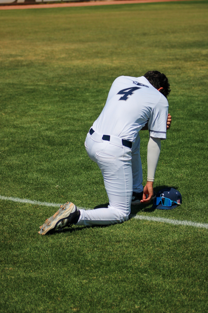 Matthew Bauer kneeling on the field before a game, jersey number 4
